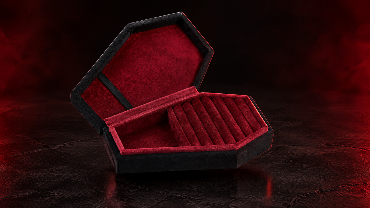 Photorealistic product visualization of the open black Reliquary Coffin Jewelry Box with burgundy interior on a dark crimson studio surface; box shown empty.