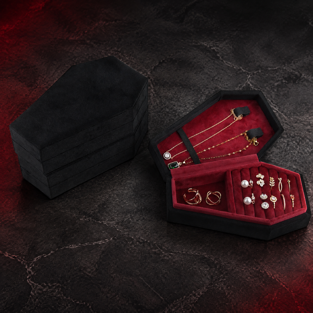 Open black Reliquary Coffin Jewelry Box with burgundy interior and a closed companion box against a dark crimson studio background; jewelry shown for illustration and is not included.