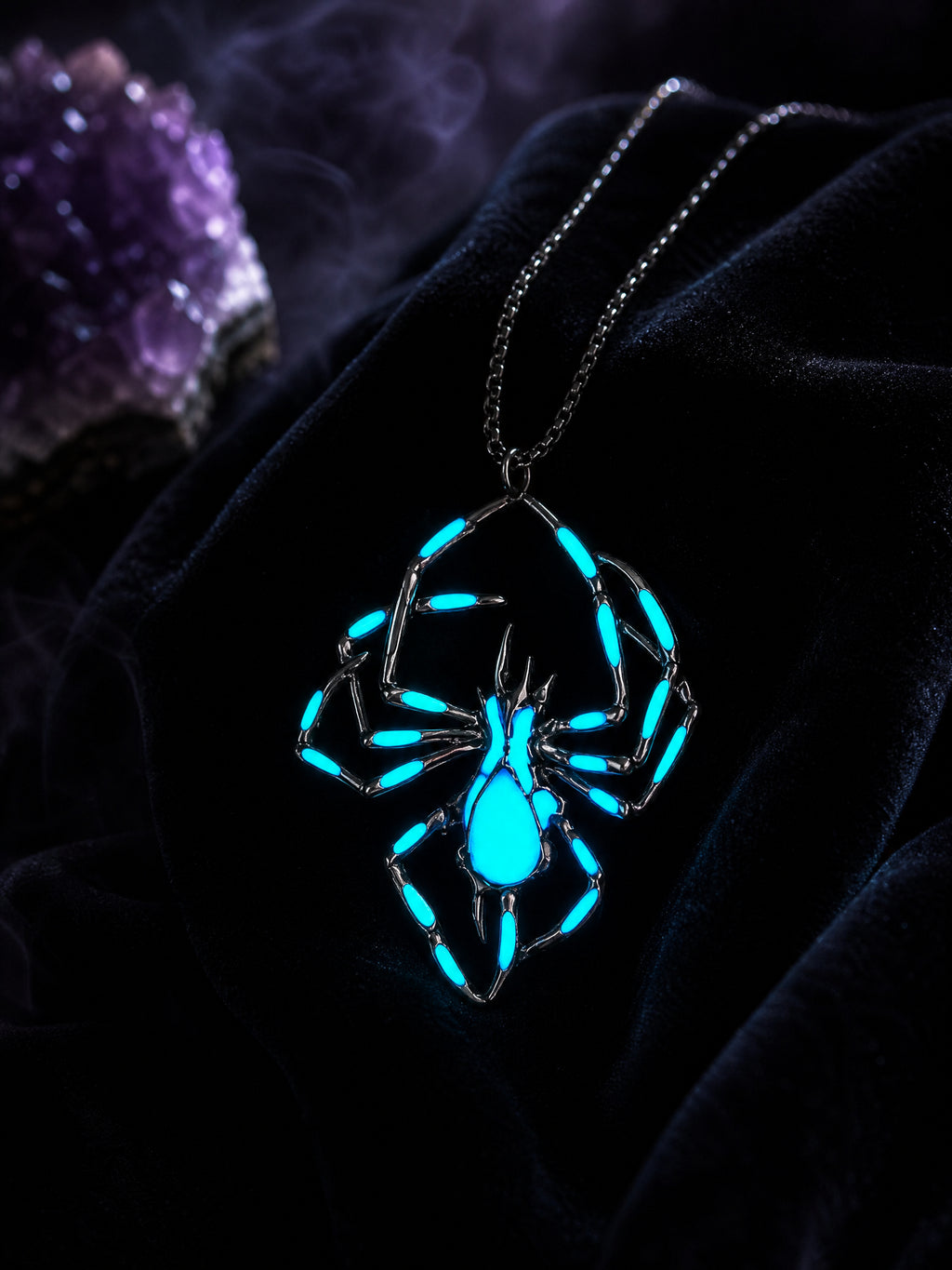 Widows Glow luminous spider necklace glowing blue on black velvet with amethyst